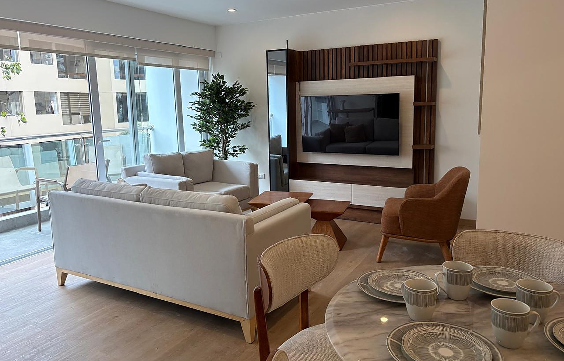 Real living room — marble table, sofas, terrace and TV wall